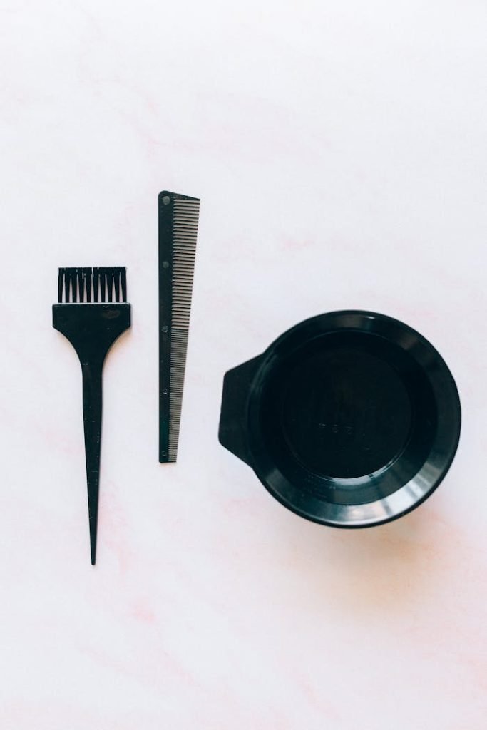 Set of hairdressing tools for color application, including brush, comb, and bowl.